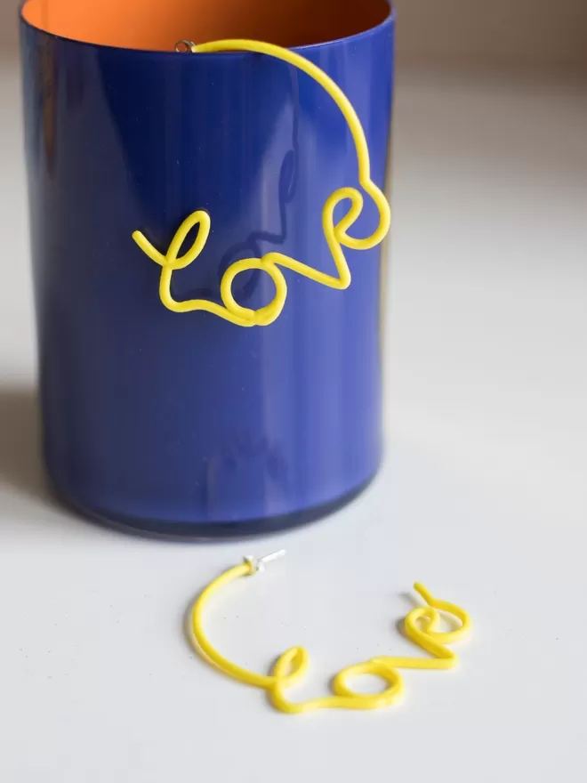 Large yellow Love hoops seen in a blue cup.