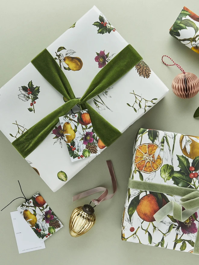 white base spaced out christmas pattern wrap with festive botanical elements shown with a co-ordinating full repeat design