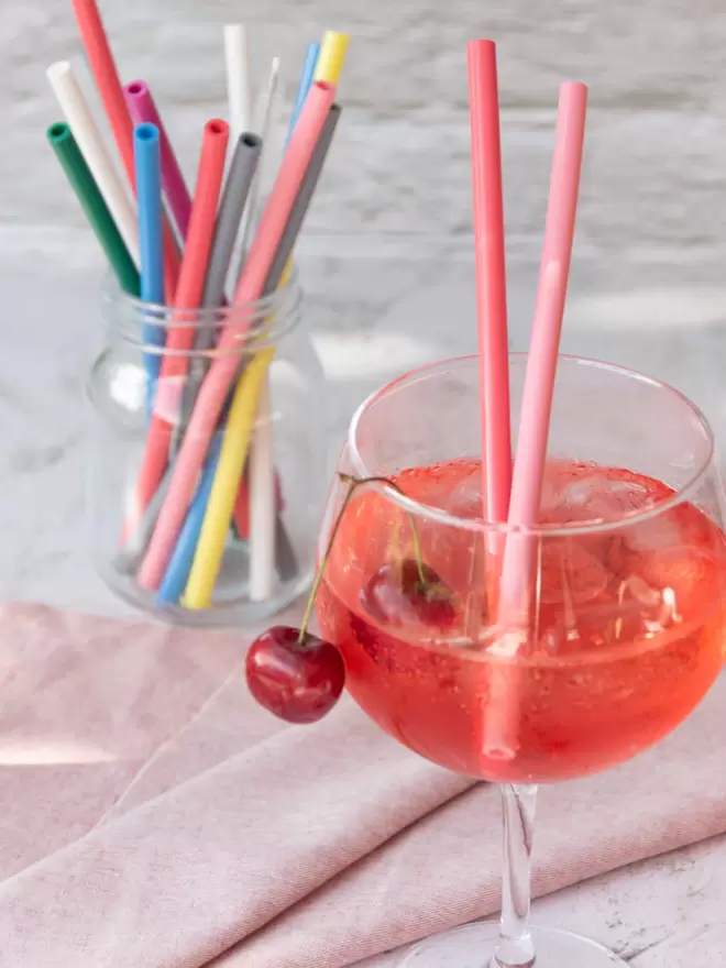 Pink Silicone straws in a gin glass