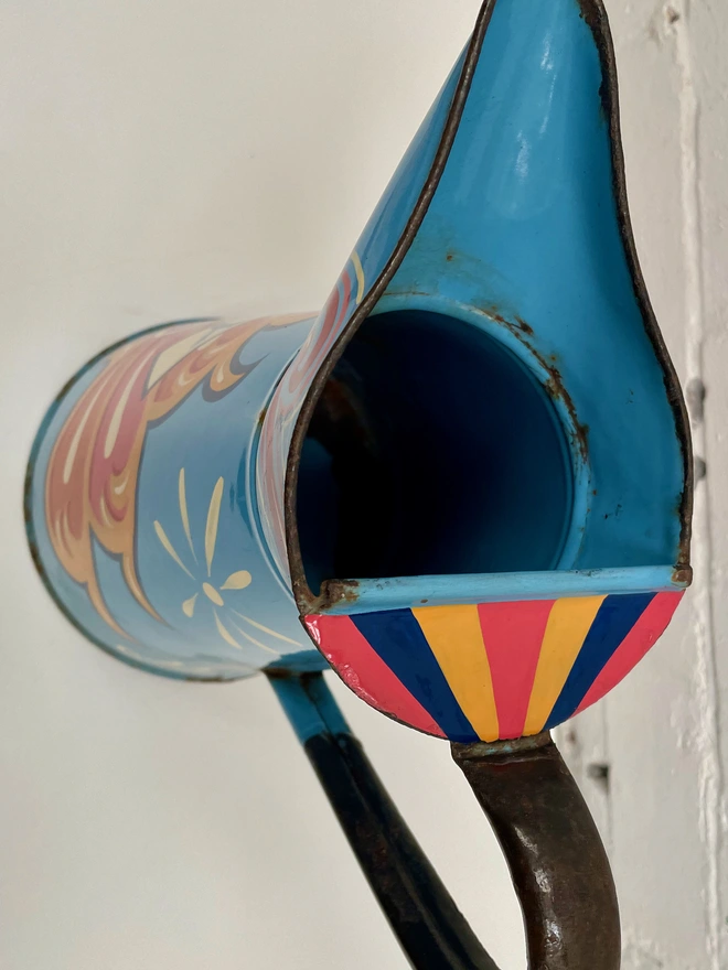 Top view of 'Joy' jug. Shows pink, yellow and blue stripe decoration on the top, and some wear to the enamel on the inside.