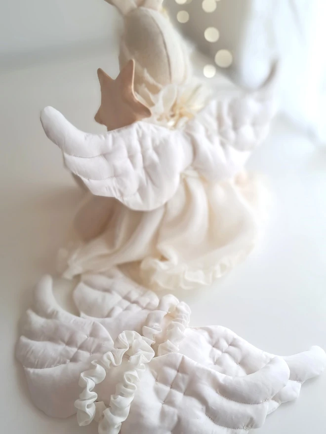 Back view of Angel Veronica Bunny showing hand-quilted satin angel wings tied with ribbon, handmade Christmas keepsake bunny