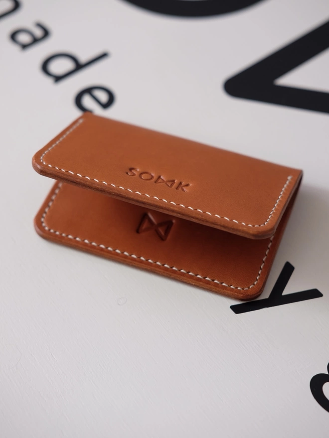 fold wallet by SOMK with white stitching and brown leather.