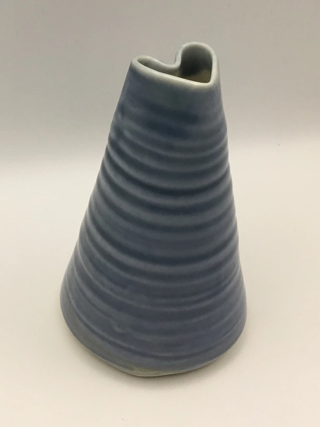 hand-thrown slate blue heart shaped bud vase. a studio image of a blue bud vase with a heart shaped opening.