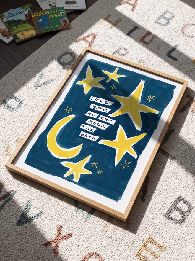 'love you to the moon and back' print. an art print with a blue background, yellow moons and stars and a slogan.