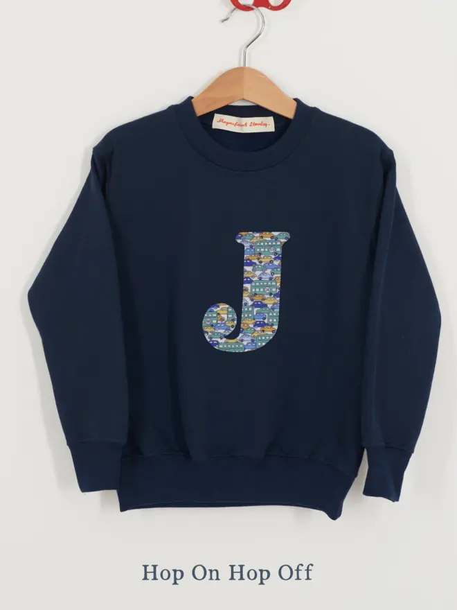 a navy kids sweatshirt with the initial J personalised in cars liberty print on the front