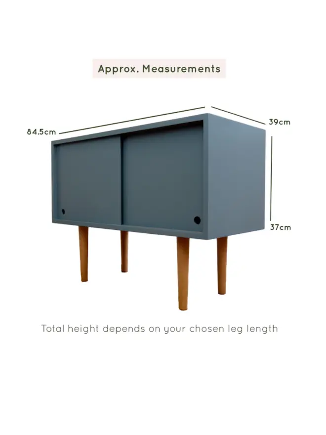 Teal mid-century cabinet in a styled living room with wooden legs.