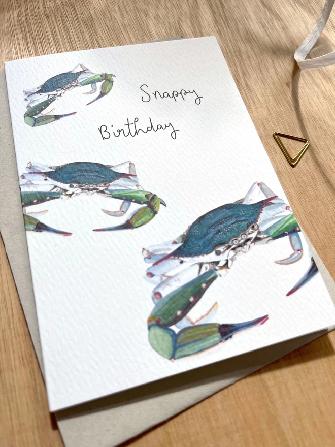 a greetings card featuring three blue crabs with the phrase “snappy birthday”