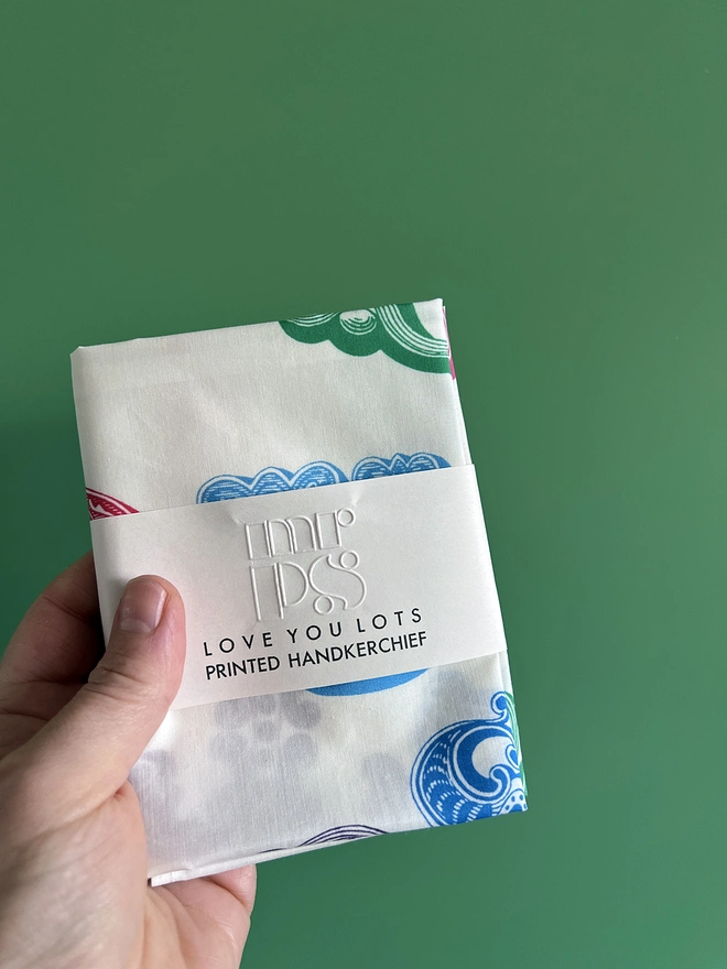 A Mr.PS Love You Lots Multicolour handkerchief folded and packaged in front of a green background
