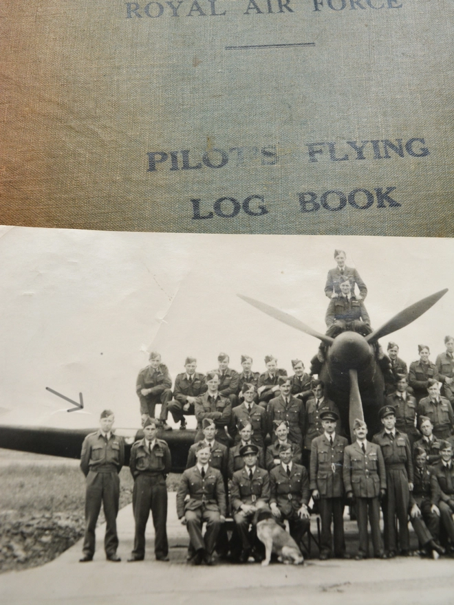 an old photograph from ww2 of the 100 squadron RAF with a war plane and pilots log book