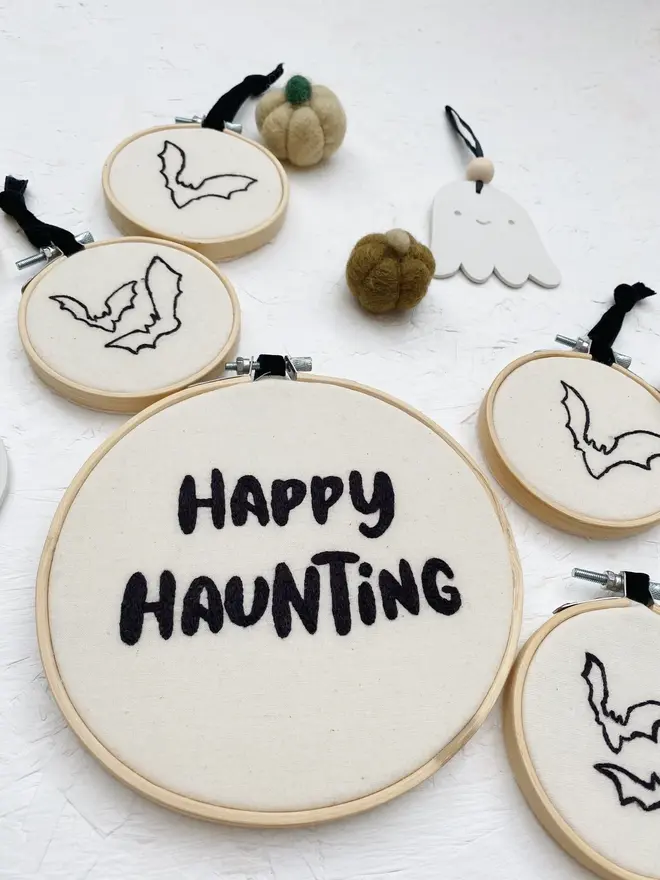 spooky phrase embroidered hoop. embroidered halloween hoops photographed with decorations.