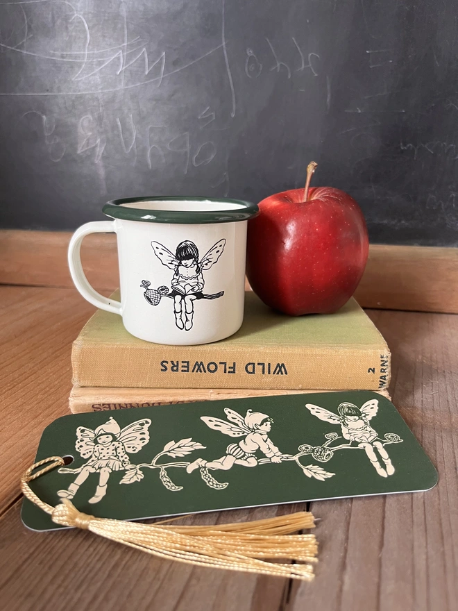 a mini enamel cream mug featuring an etching of a pixie reading a book