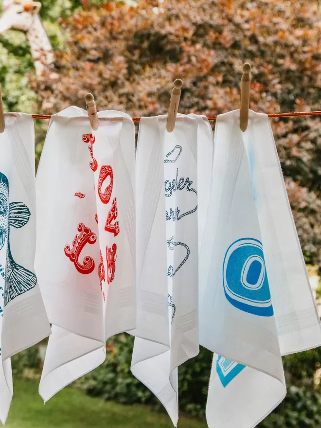A selection of Mr.PS hankies pegged on a washing line in a garden