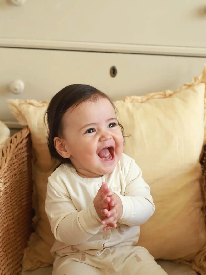 A baby wearing a sleepsuit while clapping