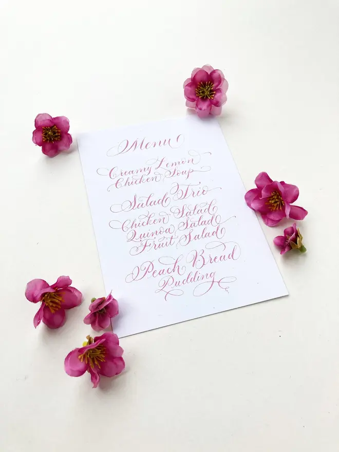 calligraphy wedding menus. white menu with pink calligraphy.