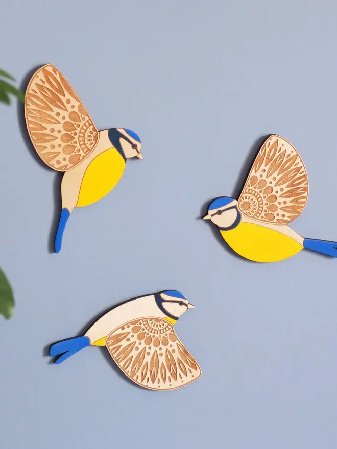 Folk Art Wooden Blue Tits (Set Of 3), wooden blue tits hung up on a wall, flying. 