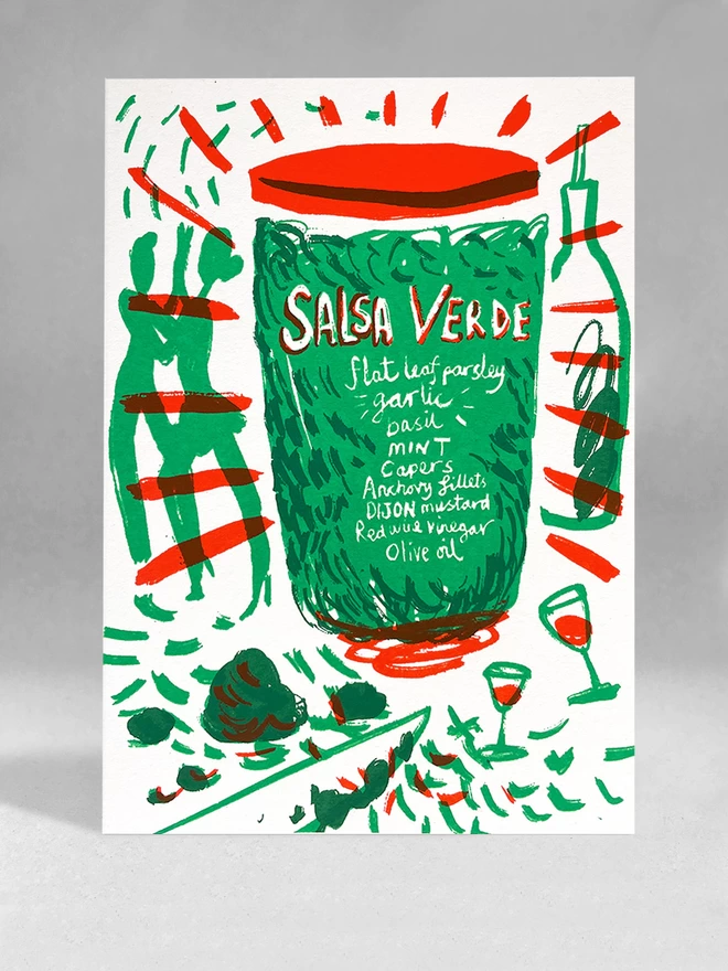 A white card with a recipe for salsa verde, printed in green and red, a pot with a recipe written on it and then chopped ingredients around, and salsa dancers in the background. Card is sat in a light grey background with soft shadows.