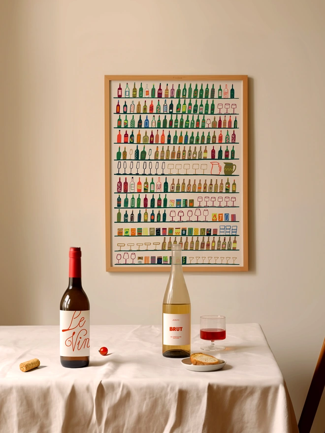 illustrated contemporary print featuring vibrant rows of drinks, bottles, wine & glasses. print shown framed against a cream wall.