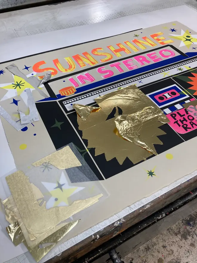 'Sunshine In Stereo' Screenprint, a group of colourful stereo screenprints on a studio rack. They read 'Sunshine in stereo. 