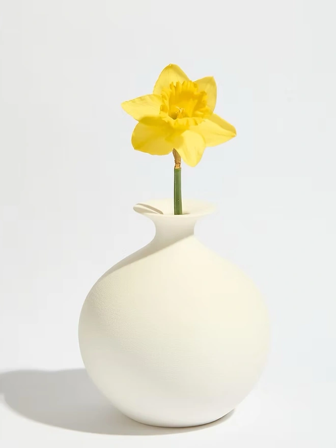 round shaped white 3d printed vase with yellow flower