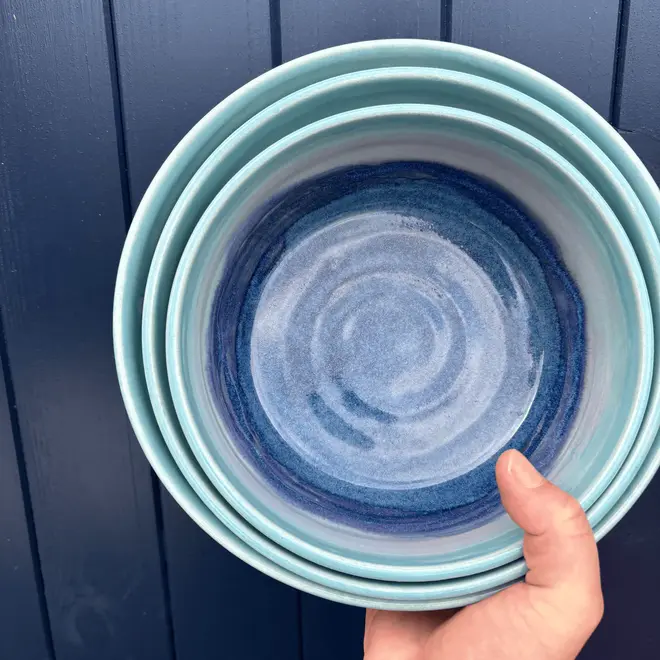 Landscape Serving Bowls (Set Of 3), a collection of colourful serving held against a navy blue door