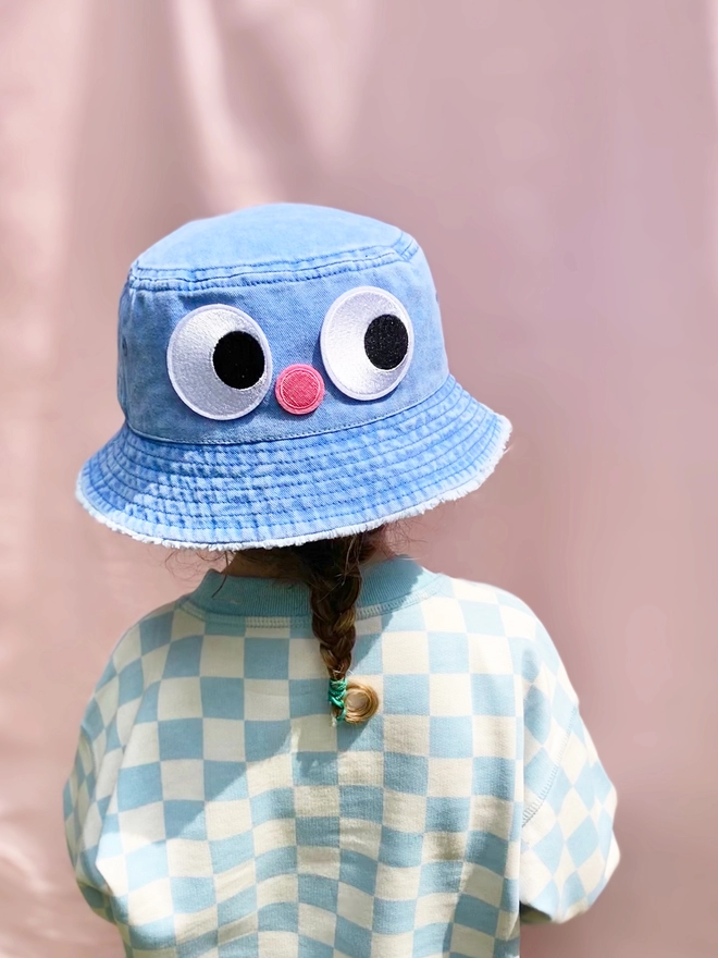 A girl wearing a hat customised with iron on patches 