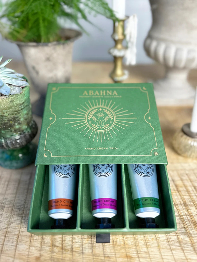 botanical hand cream trio gift set. a green gift box containing three silver tubes of hand lotion.