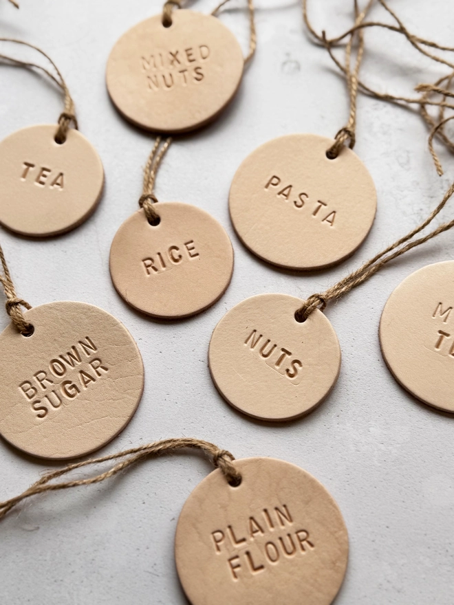 Rustic leather tag hand-stamped with "MILK", tied with jute twine on a glass bottle. Perfect for farmhouse kitchen décor, pantry organisation, or personalised gifting