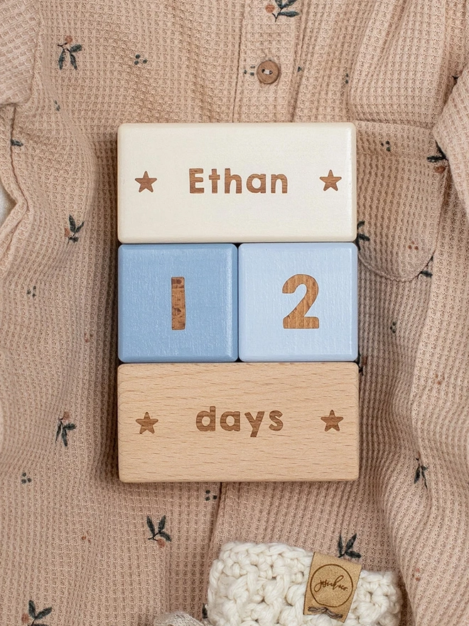 wooden baby milestone blocks with the name Ethan in sand, storm and dove colours