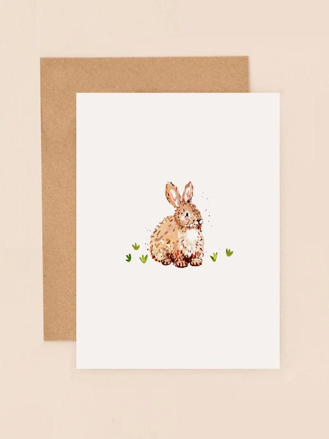 A charming illustration of a soft brown bunny sitting on a patch of green grass, exuding a gentle and serene expression. The bunny's fur is depicted with delicate strokes, highlighting its fluffy texture. The design is minimalist and heartwarming, perfect for conveying a message of kindness or appreciation.