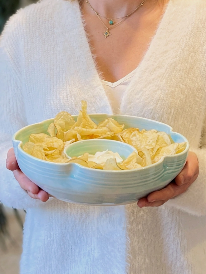 flower shaped chip and dip bowl in hands with crisps and dip