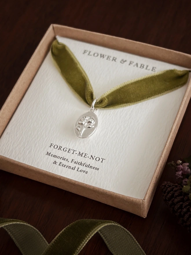 Forget me not medal charm on a green ribbon and gift box in Sterling Silver