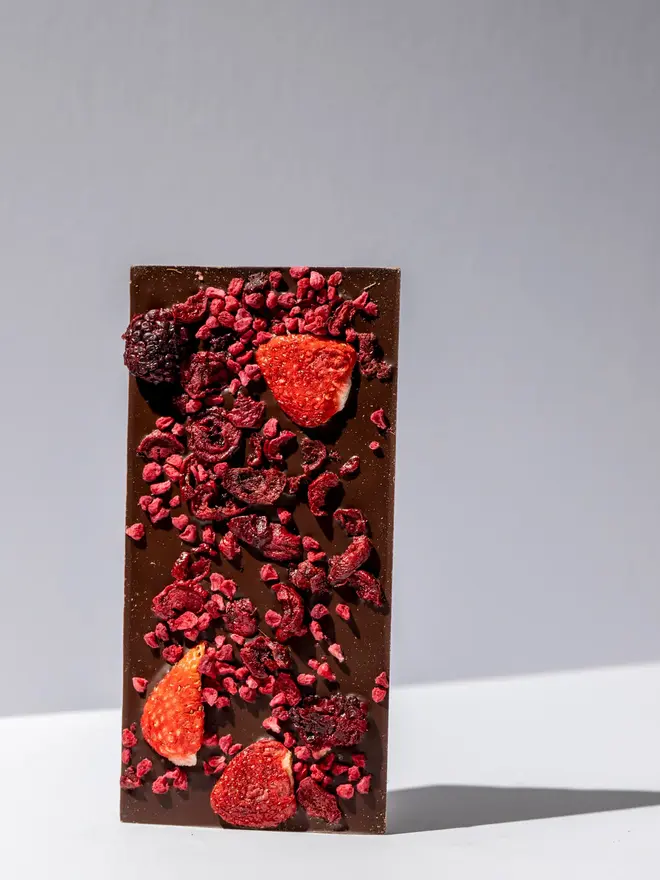 Very berry 70% chocolate tablette standing on a white table. 