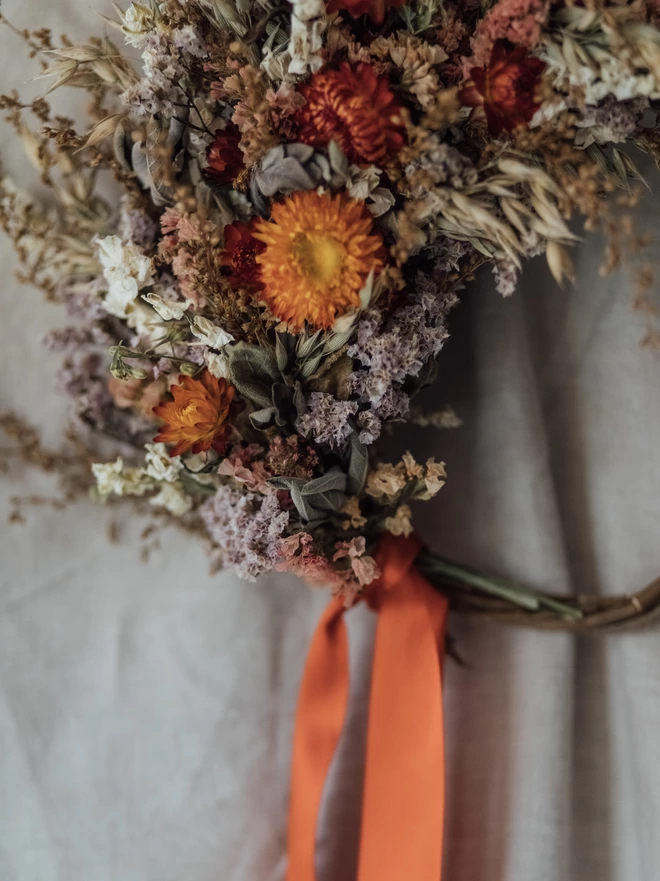 Dried Flower Wreath on a White Background with a Orange Ribbon