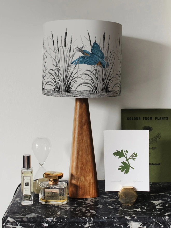 Handmade lampshade featuring vibrant kingfishers among bulrushes in a whimsical countryside-inspired design, combining nature, colour, and artisan style.