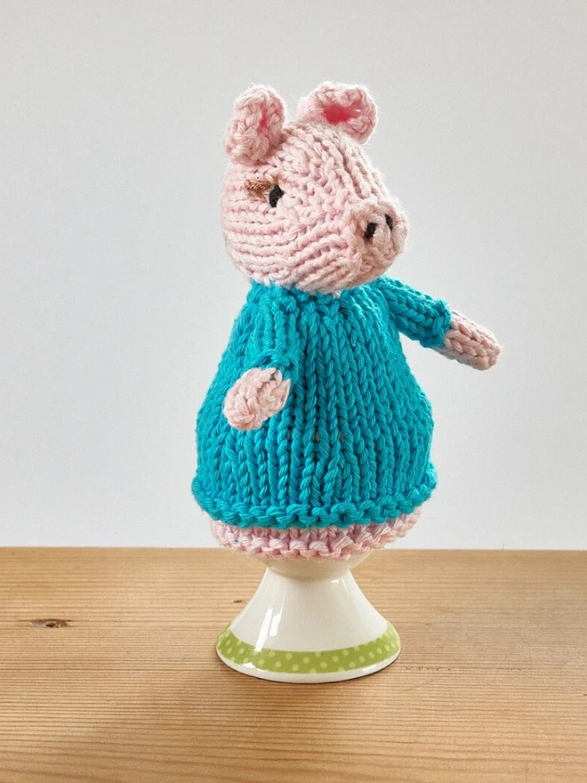 Egg Cosy Pigs Table Decoration (Set Of 2), a colourful pig cosy sitting on a wooden surface. 