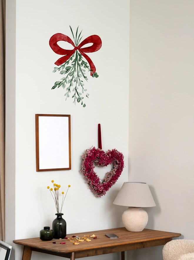 Mistletoe Christmas Wall Sticker Decals and Window Clings stuck on a wall above coffee table