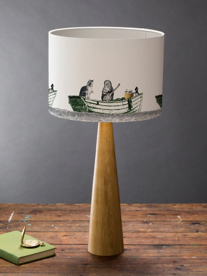 Drum Lampshade featuring the Owl and the Pussycat on a wooden base on a shelf with books and ornaments