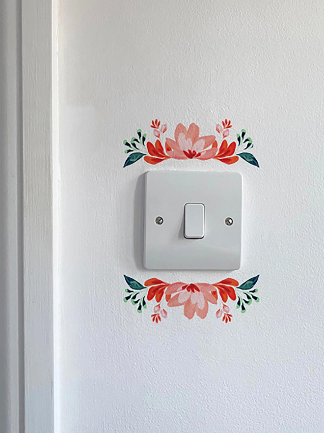 Light switch floral wall sticker, flower detail above and below light switch, handpaitnted floral design in shades of red