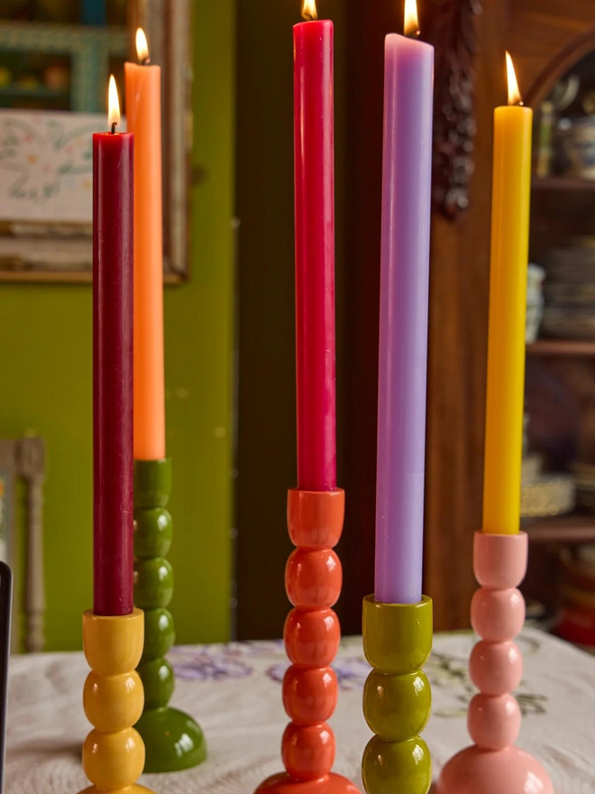 wooden candlestick holders in variety of colours lifestyle shot