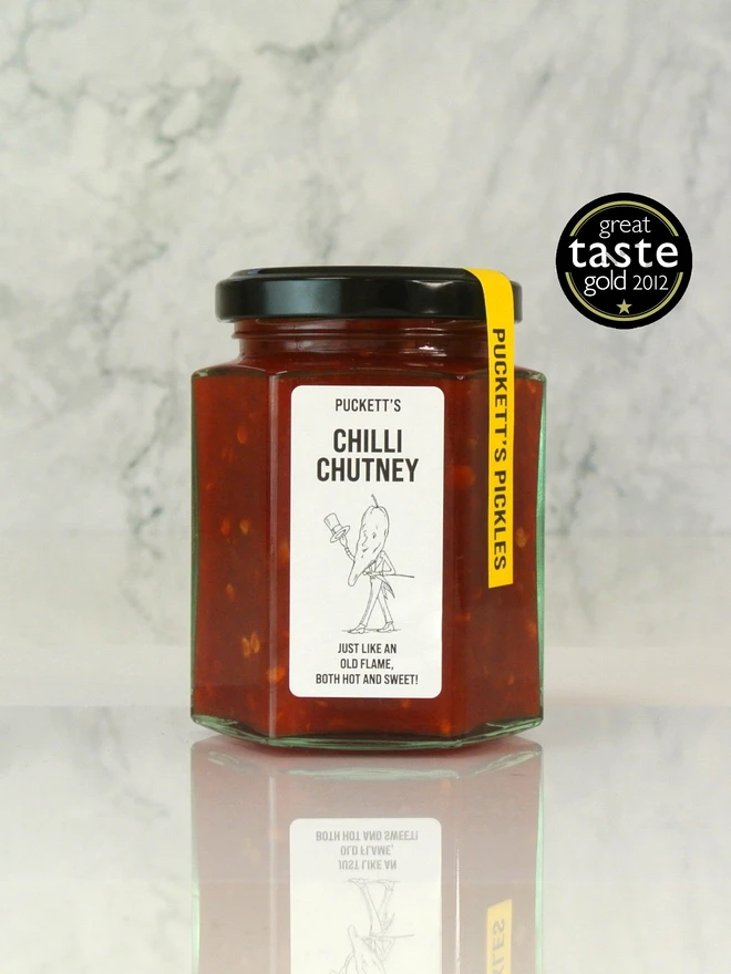 hot chilli chutney. a jar of chilli chutney photographed against a marble background.