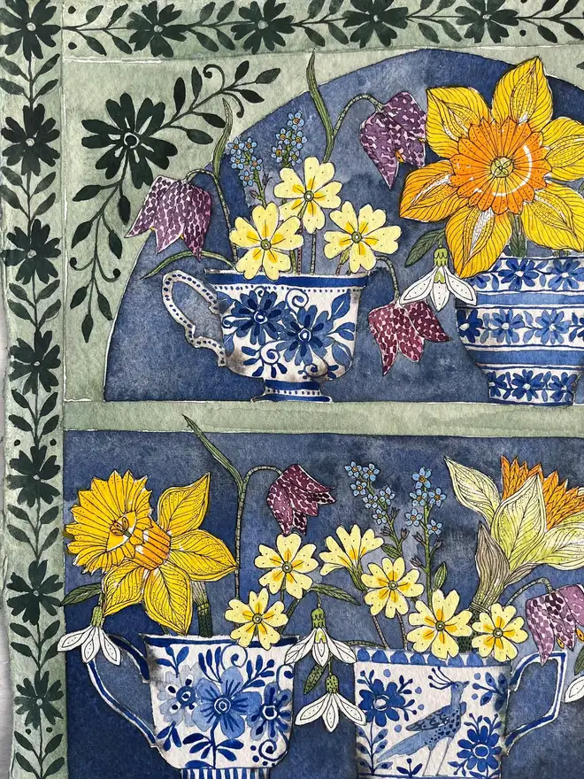 daffodils, snowdrops and spring flowers in delftware teacups displayed in a plant theatre