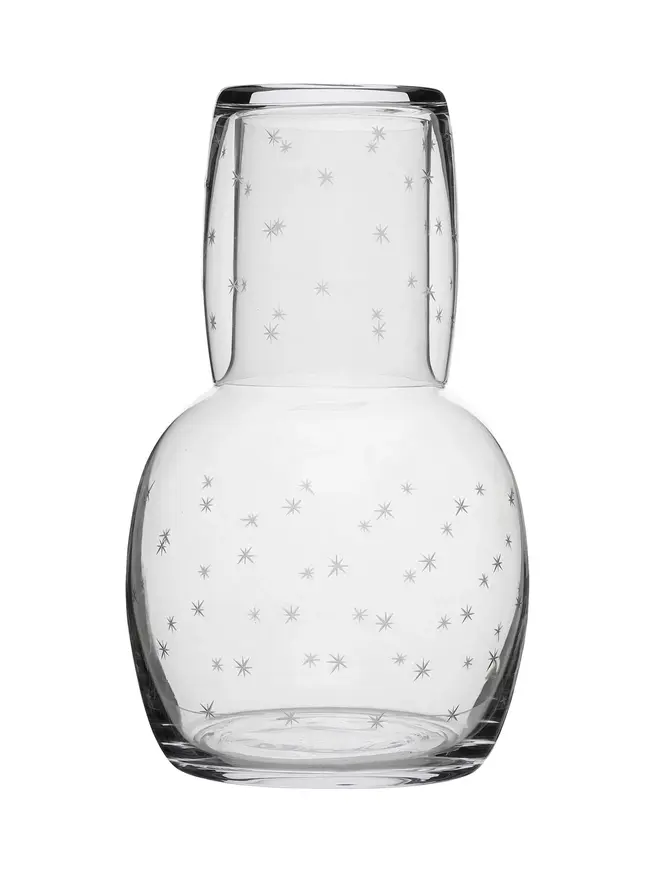engraved stars crystal carafe set. a glass carafe and small glass patterned with small stars.
