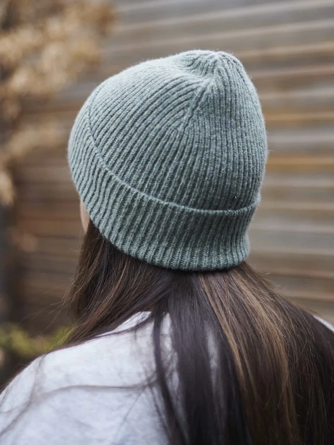 Ribbed Lambswool Women's Beanie, a woman wearing a colourful beanie outdoors. 