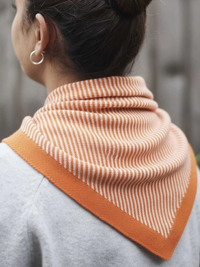 Lambswool Triangle Neck Scarf, a woman wearing a colourful neck scarf outdoors. 