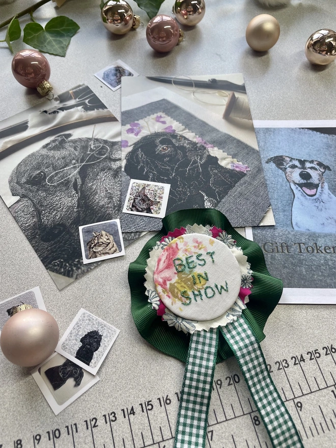 photo showing the contents of the gift token box, handmade rosette, art postcards and stickers