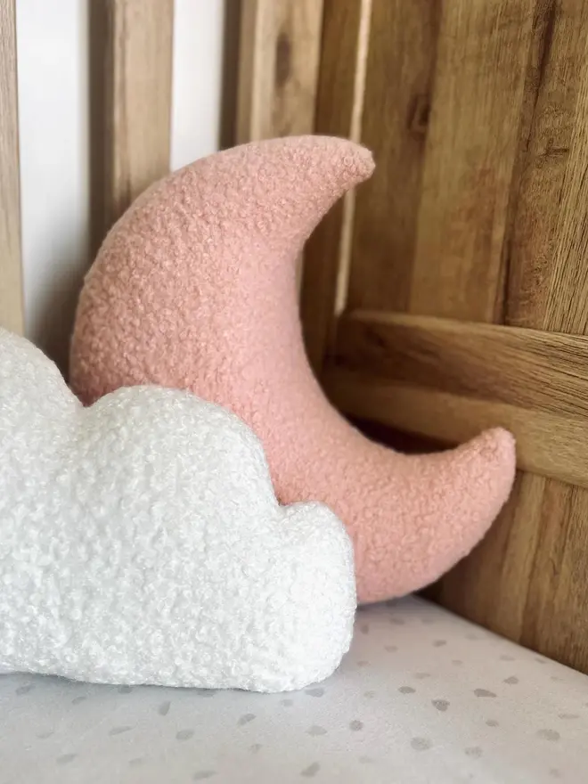 boucle moon pillow. a moon shaped pillow cushion in pink.