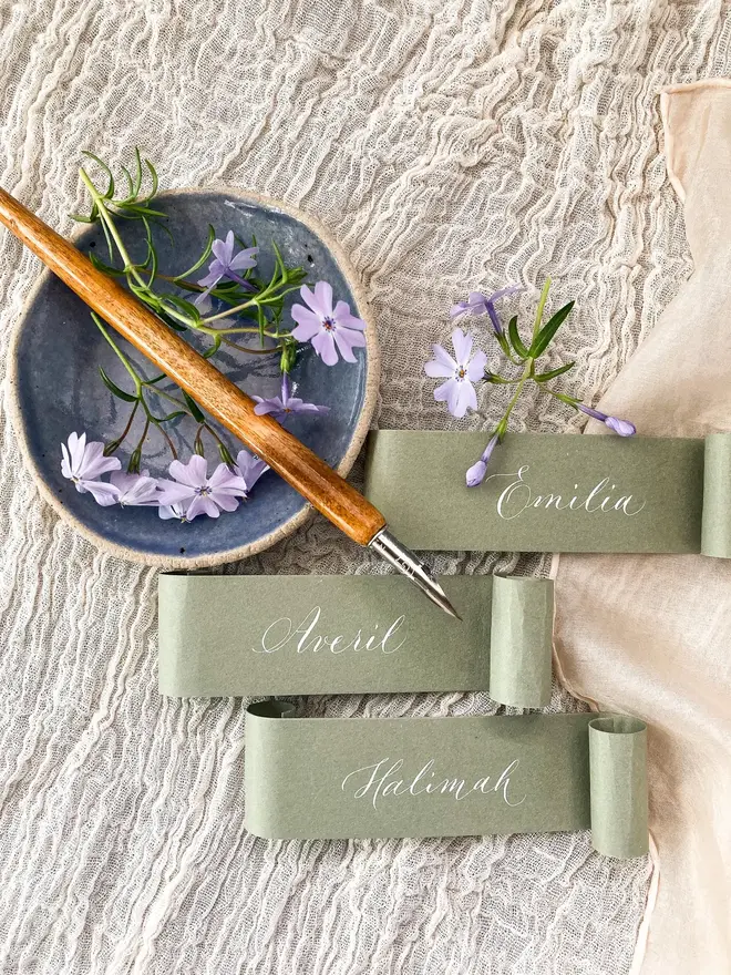 sage green scroll calligraphy wedding place cards. sage green scroll with white calligraphy.