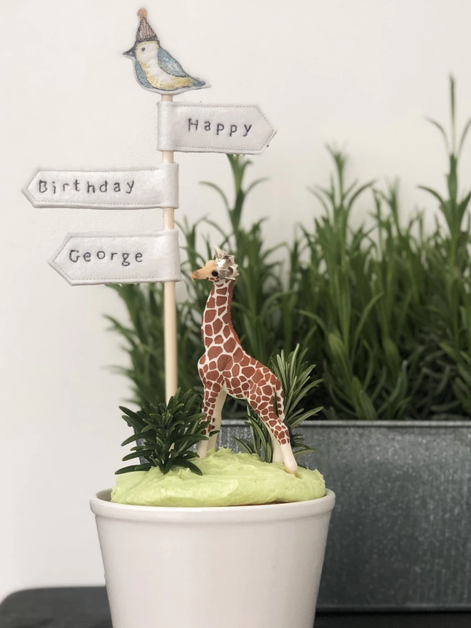 Signpost Cake Topper in a plant pot cake with a giraffe