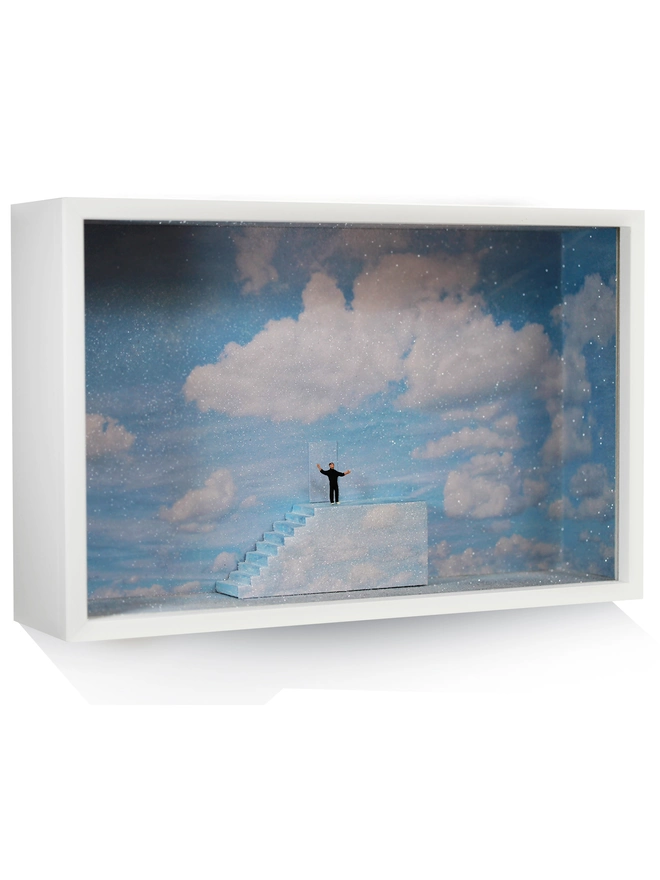 Diorama in which miniature Truman stands at the top of the stairs, ready to open the door to reality., set against a sparkling sky