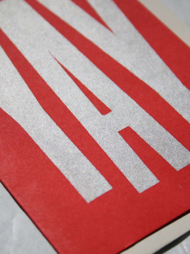 Red greeting card with the word yay printed in silver using a linocut block